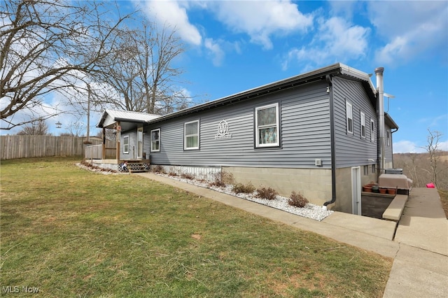 view of home's exterior with a yard and fence