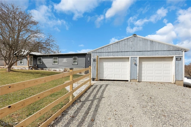 ranch-style house featuring an outbuilding, fence, and a front lawn