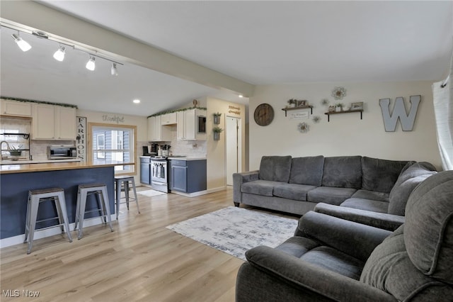 living area with light wood-type flooring and vaulted ceiling