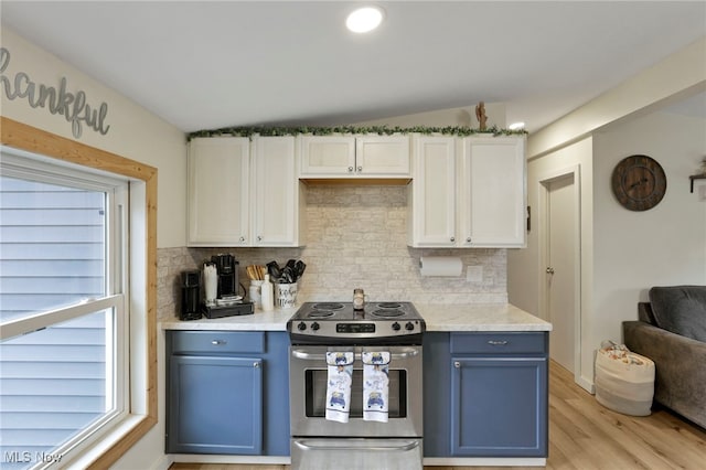 kitchen with blue cabinets, stainless steel electric range oven, and a wealth of natural light