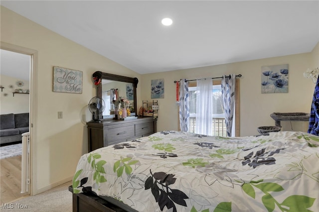 bedroom with lofted ceiling, light carpet, and baseboards