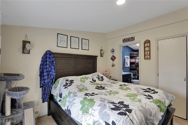 bedroom featuring connected bathroom and baseboards