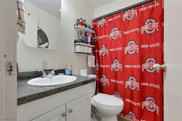 full bathroom featuring a shower with shower curtain, vanity, and toilet