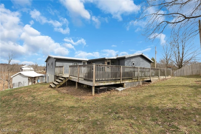 rear view of house featuring a yard, fence, and a deck