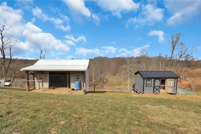 exterior space with an outbuilding, metal roof, and a yard