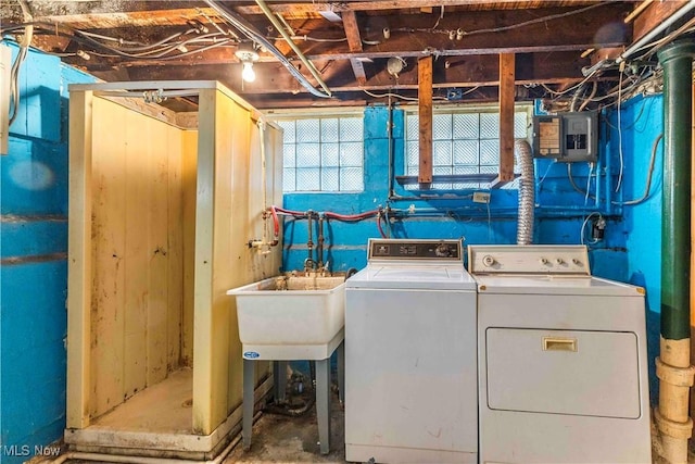 clothes washing area featuring laundry area, electric panel, separate washer and dryer, and a sink