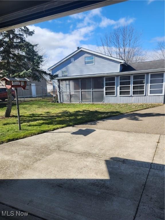 view of front facade with a front yard and a sunroom