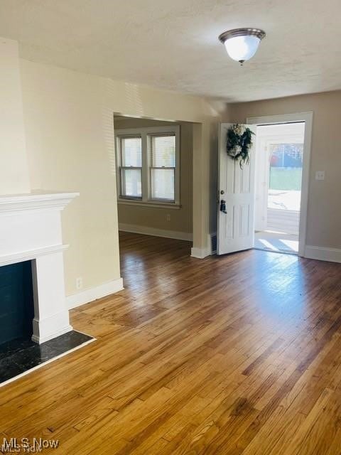 interior space with a fireplace, wood finished floors, and baseboards