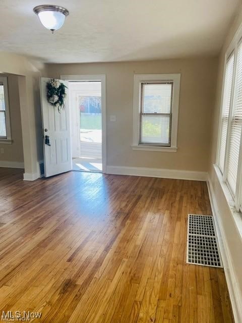 interior space featuring visible vents, light wood-style flooring, and baseboards