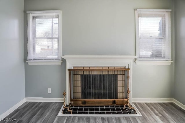 details with a tile fireplace, baseboards, and wood finished floors