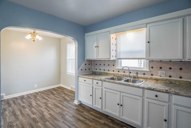 kitchen featuring white cabinetry, a sink, and decorative backsplash