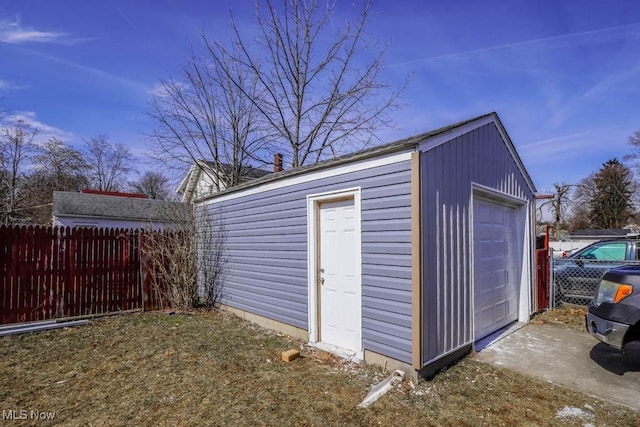 view of outbuilding featuring fence and an outbuilding