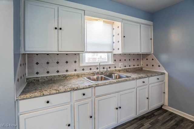 kitchen featuring backsplash, a sink, and white cabinets