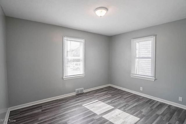 unfurnished room with plenty of natural light, visible vents, and baseboards