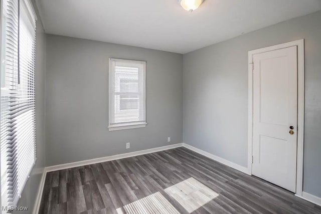 empty room featuring wood finished floors and baseboards