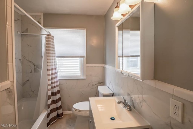 full bath featuring a wainscoted wall, shower / tub combo with curtain, tile walls, toilet, and vanity