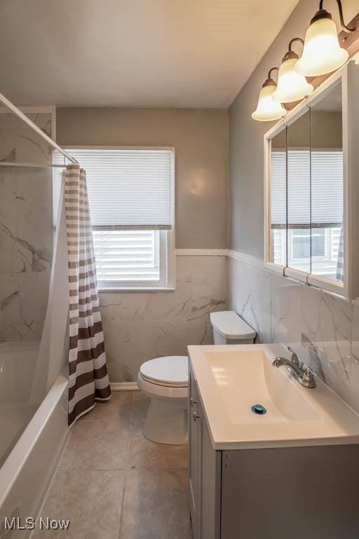 full bath with a wealth of natural light, vanity, toilet, and shower / tub combo with curtain