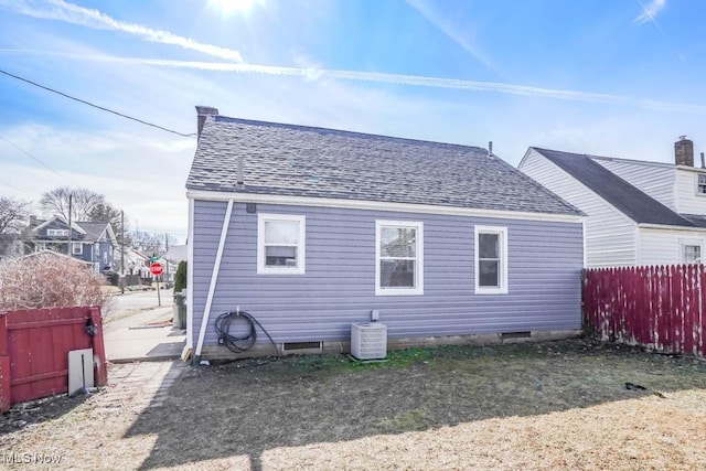 back of house featuring a shingled roof, crawl space, central AC unit, and fence