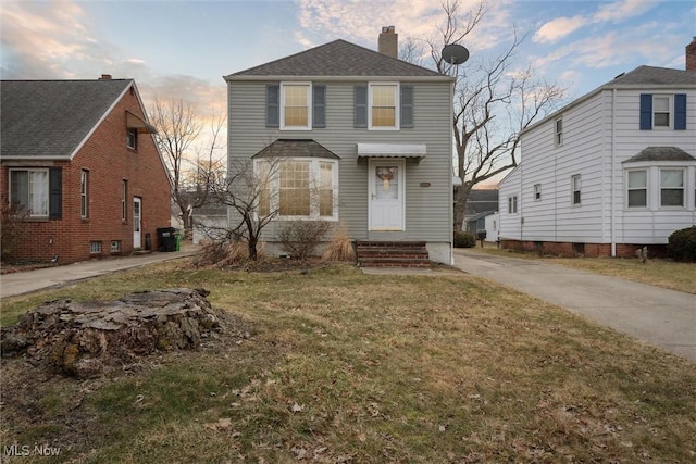 traditional home featuring a yard and a chimney