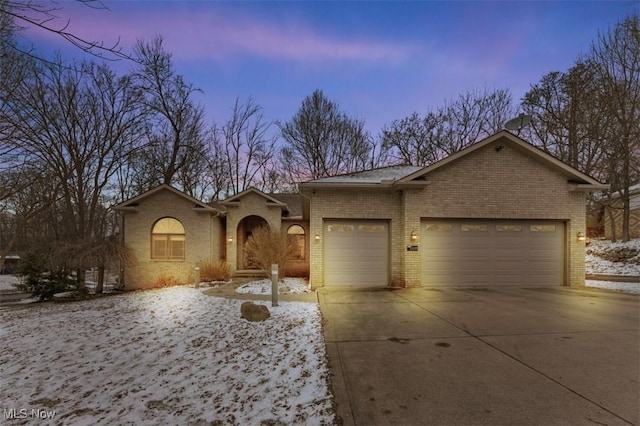 single story home with an attached garage, concrete driveway, and brick siding