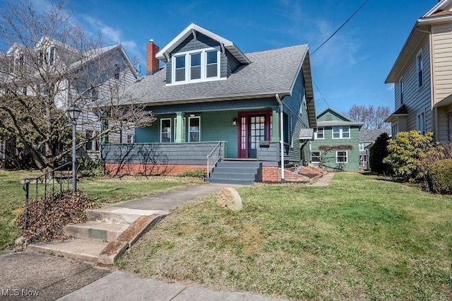 bungalow-style home featuring a front yard, covered porch, and roof with shingles