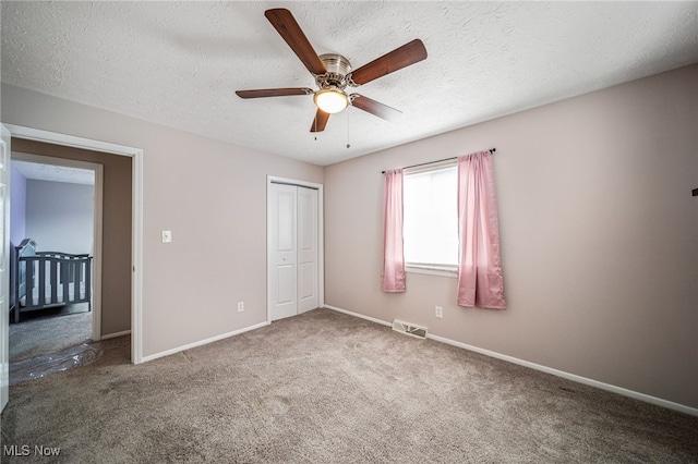 unfurnished bedroom featuring carpet floors, a closet, visible vents, and baseboards