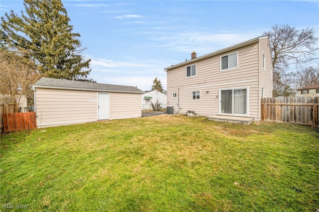 back of house featuring a lawn, a chimney, fence, an outdoor structure, and central AC