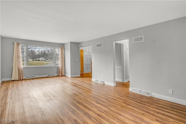 spare room featuring light wood finished floors and visible vents