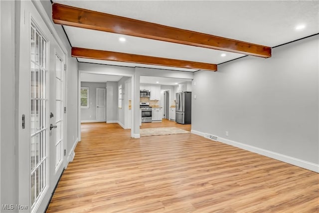 spare room featuring light wood finished floors, visible vents, baseboards, beam ceiling, and recessed lighting