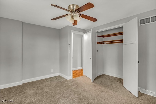 unfurnished bedroom featuring carpet, a closet, visible vents, a ceiling fan, and baseboards