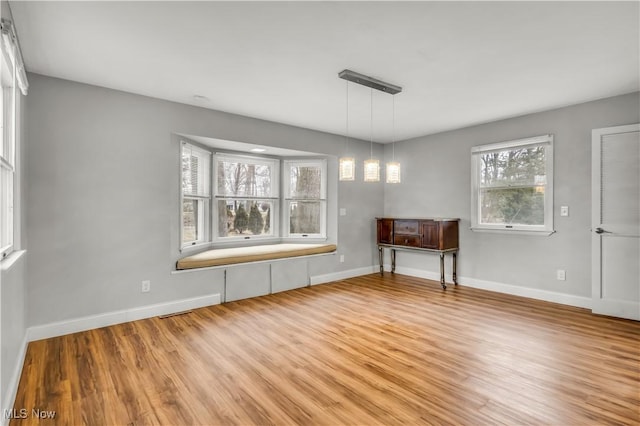 unfurnished dining area featuring light wood finished floors and baseboards