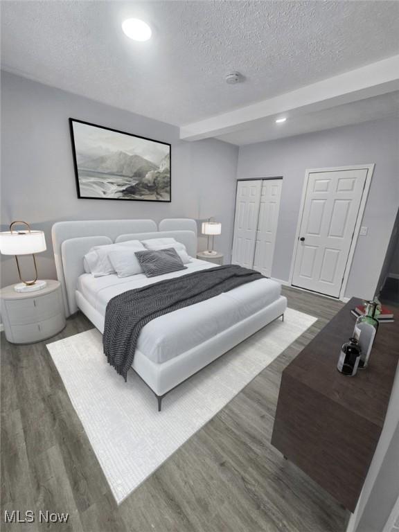 bedroom featuring a closet, a textured ceiling, wood finished floors, and recessed lighting