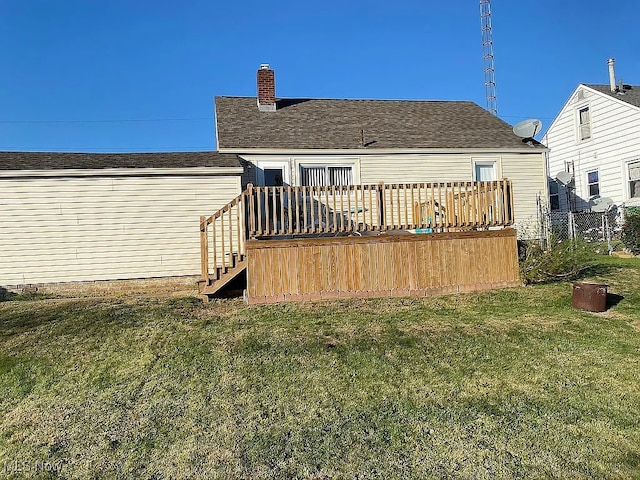 rear view of house featuring roof with shingles, stairway, a deck, and a yard