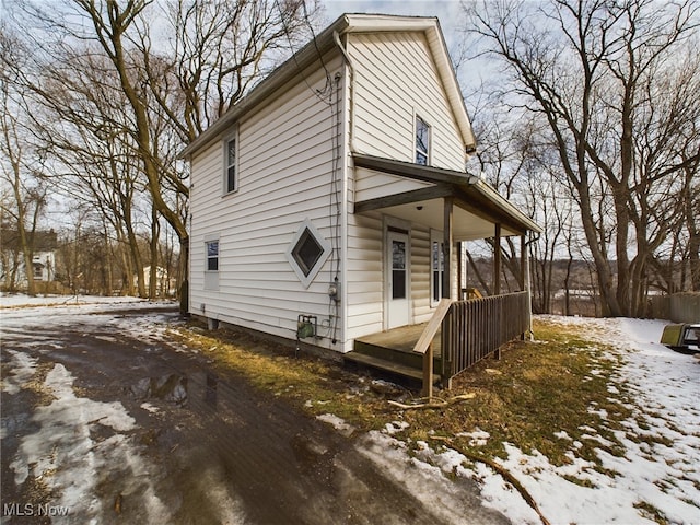 view of snowy exterior with covered porch