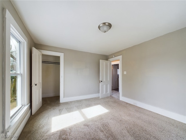 unfurnished bedroom featuring baseboards and light colored carpet