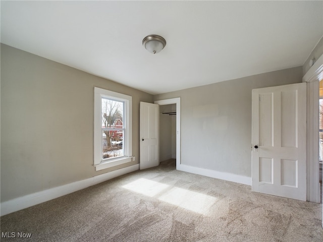 unfurnished bedroom with a closet, carpet flooring, and baseboards