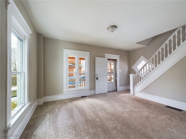 interior space featuring plenty of natural light, visible vents, and carpet flooring