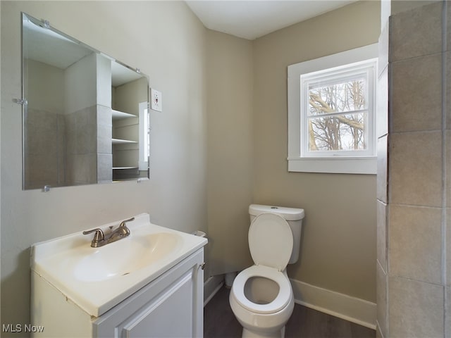 bathroom with vanity, toilet, and baseboards