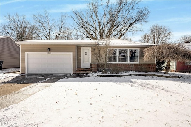 ranch-style house with a garage, brick siding, and driveway