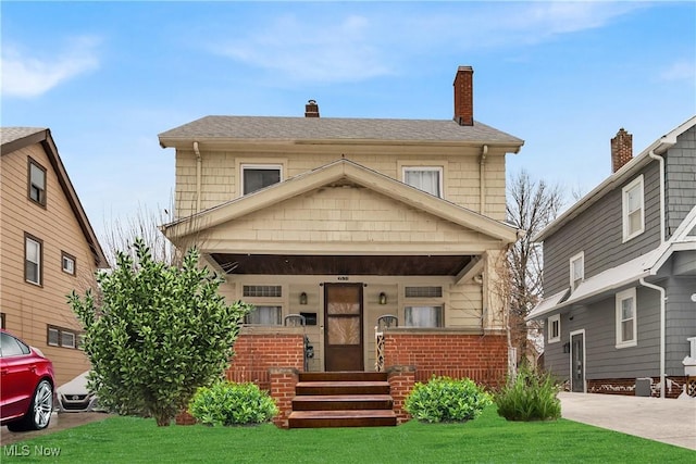 view of front of home with a front yard and covered porch