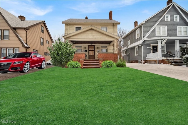 back of property featuring a porch, a lawn, and a chimney