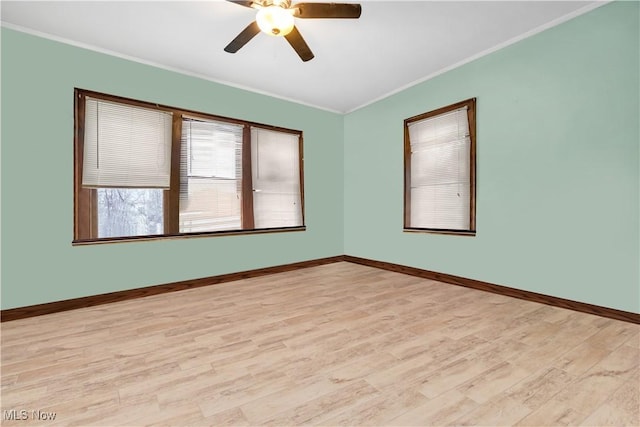 unfurnished room with ornamental molding, light wood-type flooring, and baseboards