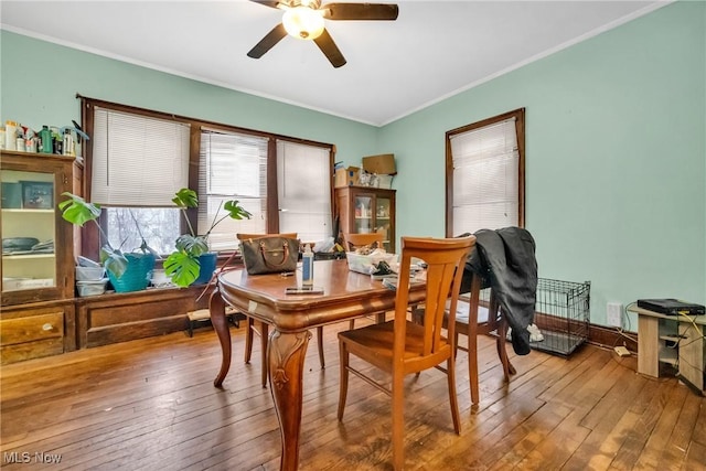 dining area with ornamental molding, wood-type flooring, and a ceiling fan