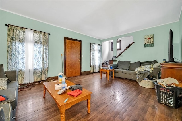 living area with arched walkways, baseboards, and hardwood / wood-style flooring