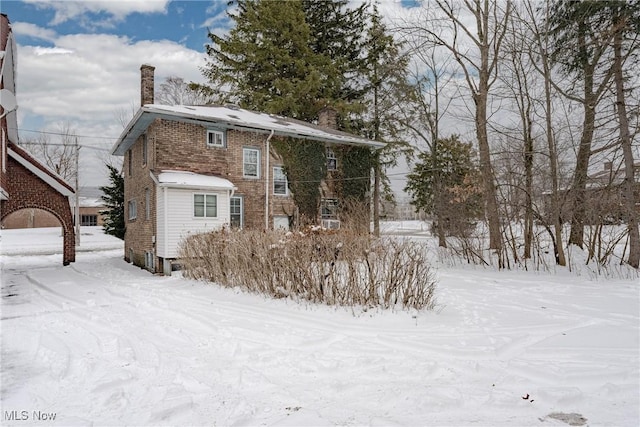 view of front of house with a chimney and brick siding