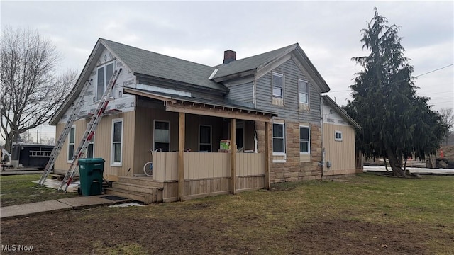 view of side of home featuring stone siding, a chimney, and a yard