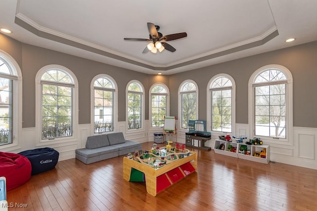 playroom with hardwood / wood-style floors and a raised ceiling