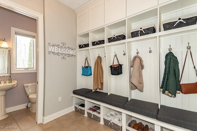 mudroom with light tile patterned flooring and baseboards