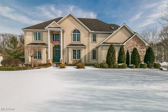 view of front facade featuring stone siding and stucco siding