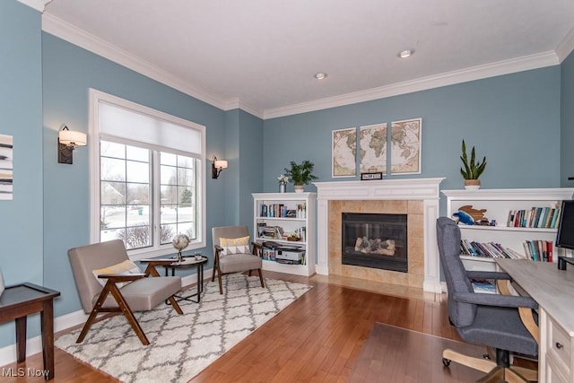 sitting room featuring ornamental molding, a tile fireplace, and wood-type flooring